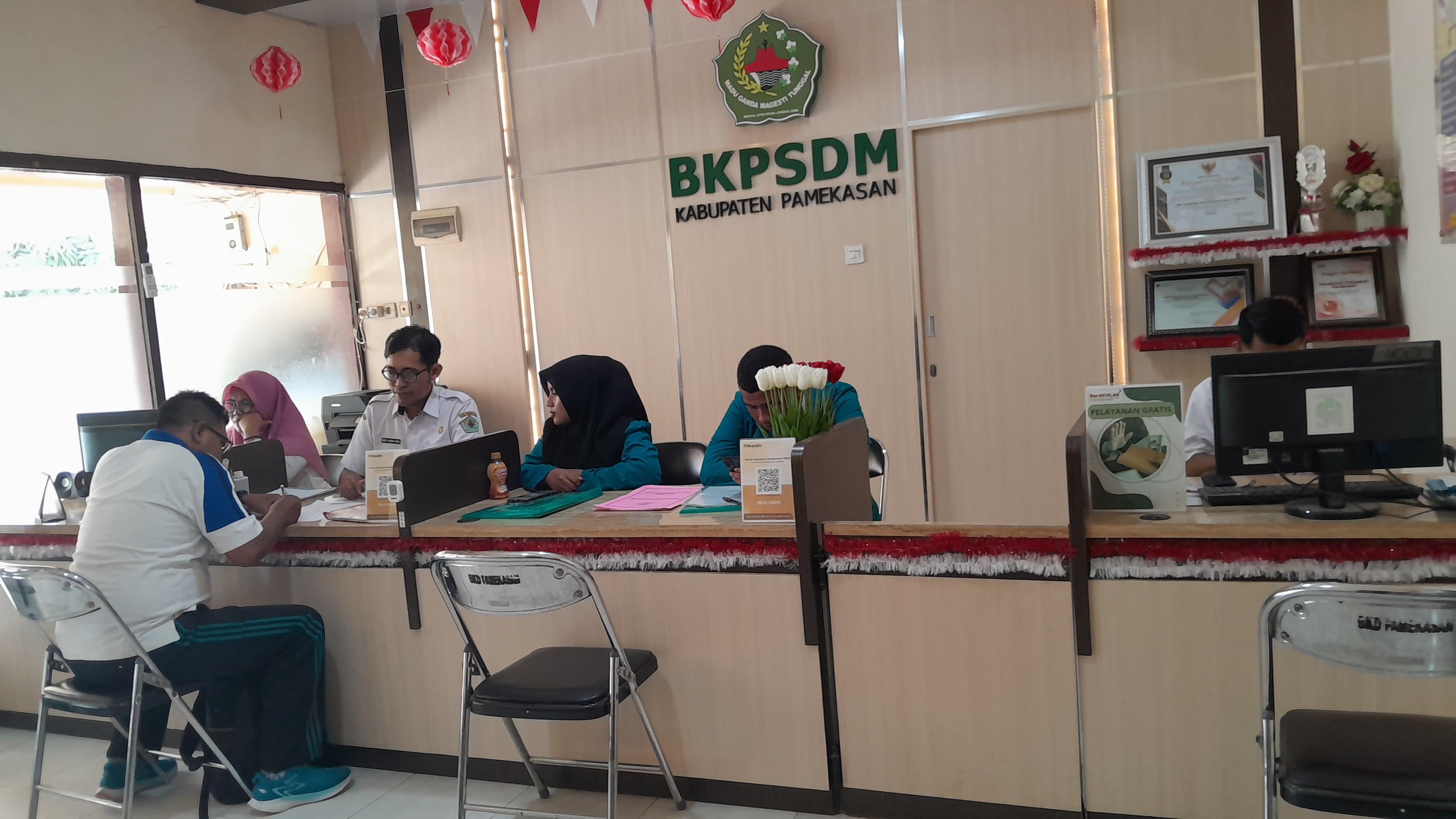 ABDI NEGARA: Pegawai BKPSDM Pamekasan sedang melayani tamu di ruang lobi kantor, Rabu (7/8). (KHOLIL RAMLI/JPRM)