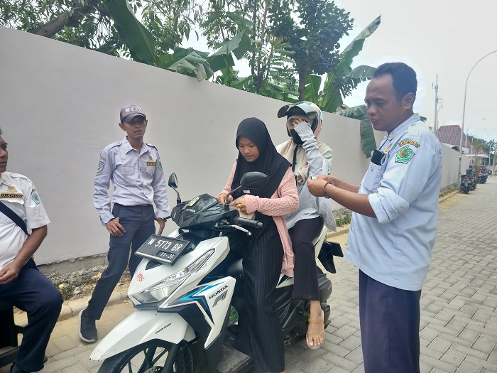 RAWAN BOCOR: Petugas mengecek karcis kendaraan milik pengunjung Pasar Kolpajung, Pamekasan, Rabu (7/8). (LAILIYATUN NURIYAH/JPRM)