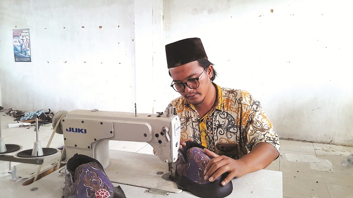 PRODUKTIF: Zubair Ali Mortadho mempraktikkan proses pembuatan sepatu di Desa Seddur, Kecamatan Pakong, Pamekasan, Sabtu (3/8). (M. KHOLIL RAMLI/JPRM)
