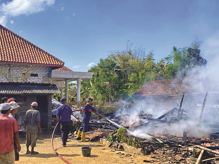 LUDES: Tim pemadam kebakaran tengah memadamkan sisa api di TKP kebakaran rumah Rofi&rsquo;i, Desa Anggersek, Camplong, Sampang, Minggu (11/8). (DINAS DAMKAR UNTUK JPRM)