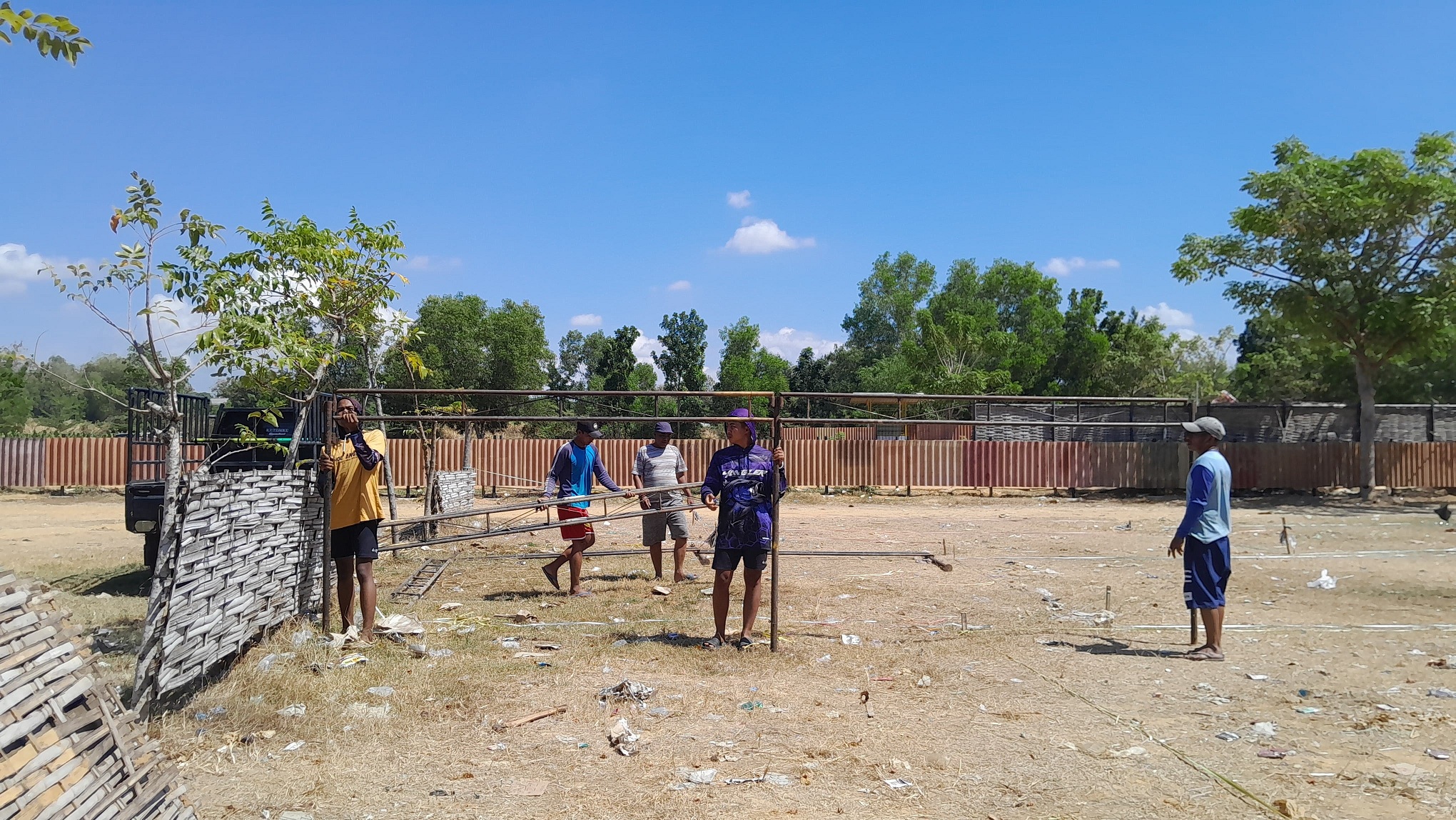 DI BAWAH TERIK: Sekelompok orang memasang tenda untuk persiapan lomba karapan sapi tingkat kabupaten di Lapangan Asem Manis, Desa Murtajih, Pademawu, Pamekasan, kemarin. (M. KHOLIL RAMLI/JPRM)