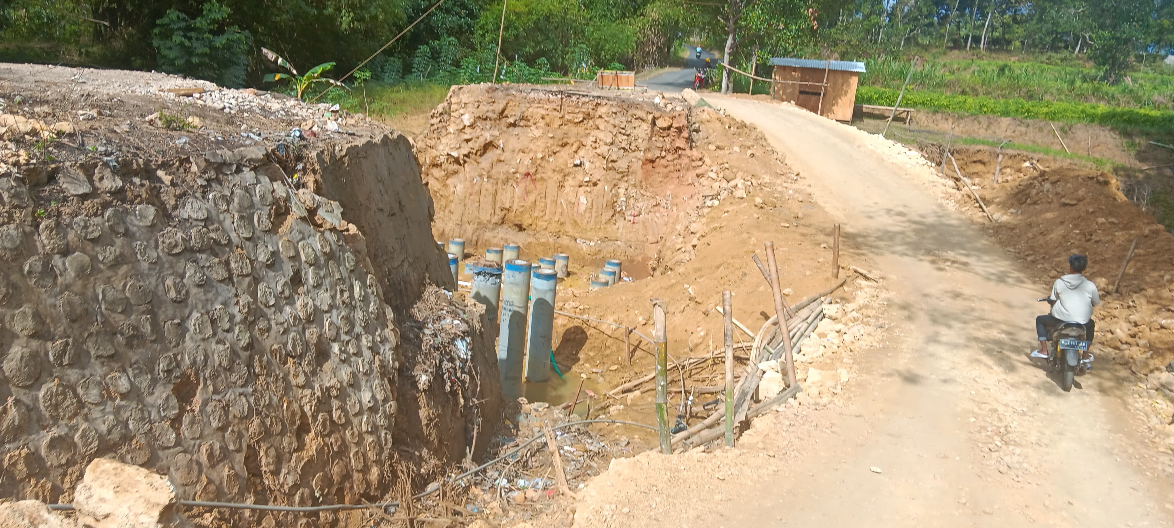 PROSES PENGERJAAN: Pengendara melintas di sekitar proyek pengerjaan Jembatan Rubaru di Desa Pakondang, Kecamatan Rubaru, yang dikerjakan CV Elang Emas pada Kamis (1/8).(ADI&nbsp;UNTUK JPRM)