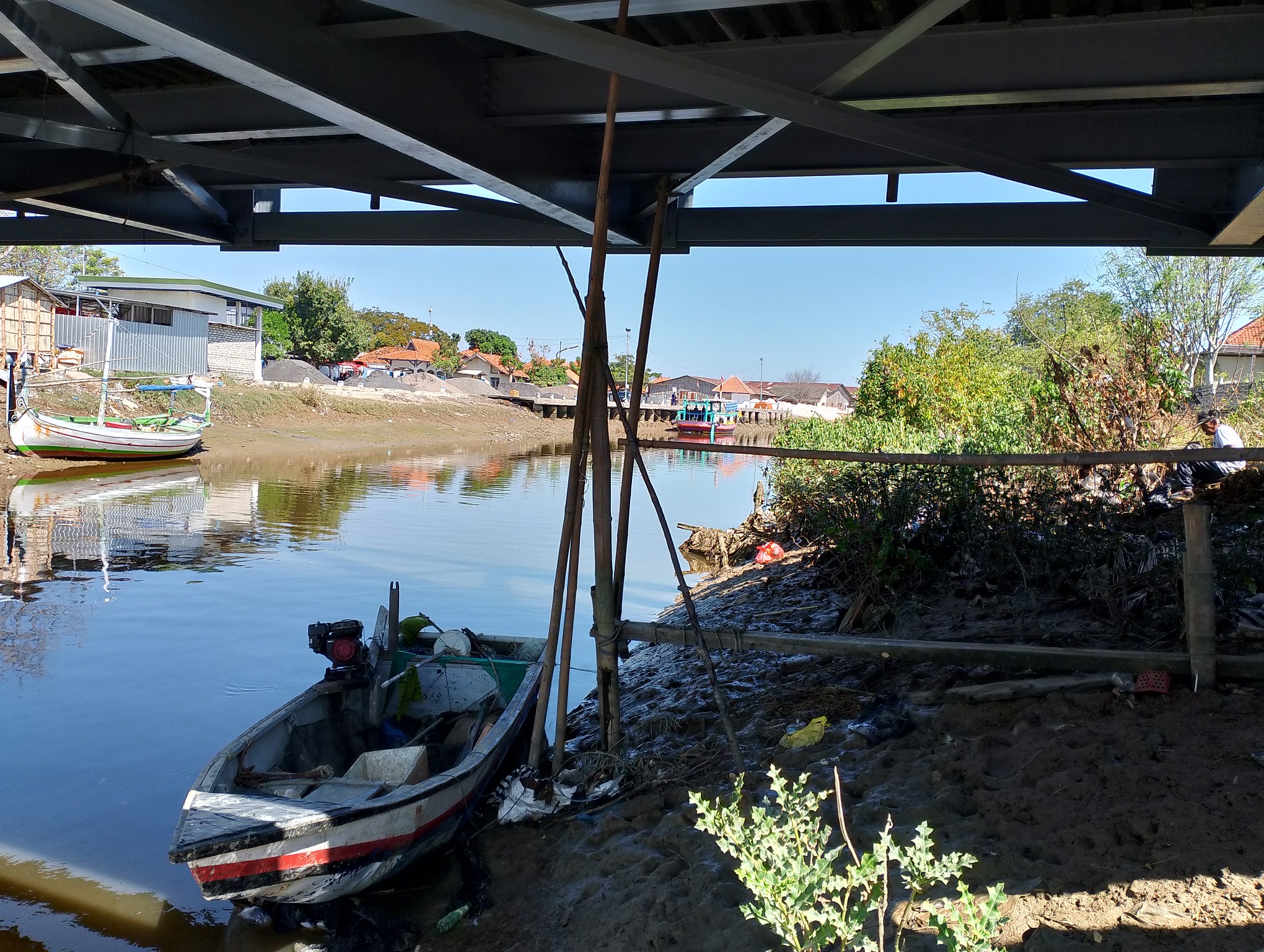 TIDAK MELAUT: Warga mengamati perahu yang sedang sandar di sekitar Pelabuhan Tanglok, Kelurahan Banyuanyar, Kecamatan Kota Sampang, kemarin. (UBAIDILLAHIR RA&rsquo;IE/JPRM)
