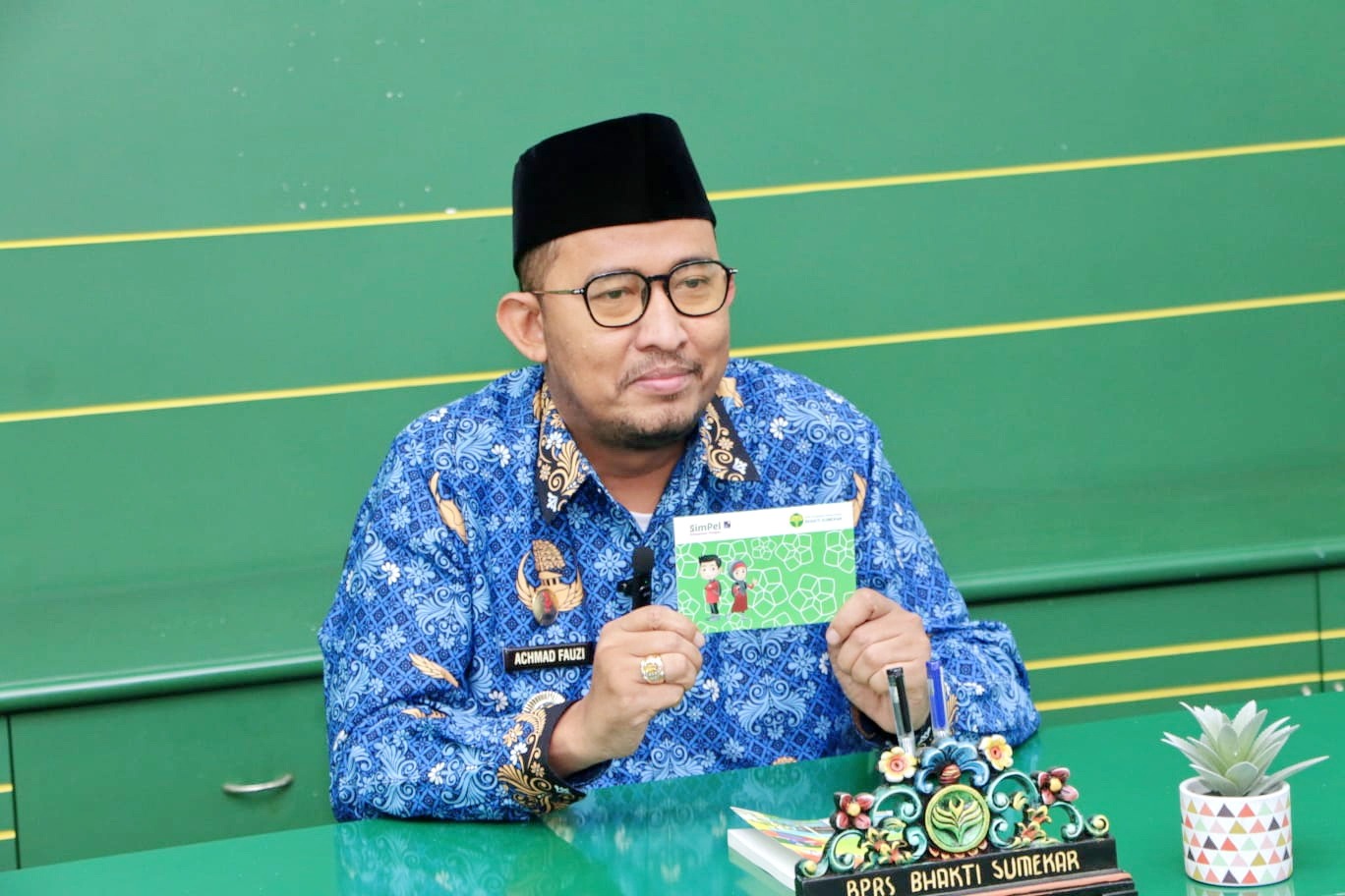 PROGRAM UNGGULAN: Bupati Sumenep Achmad Fauzi Wongsojudo memegang tabungan SimPel BPRS Bhakti Sumekar. (BPRS BHAKTI SUMEKAR UNTUK JPRM)