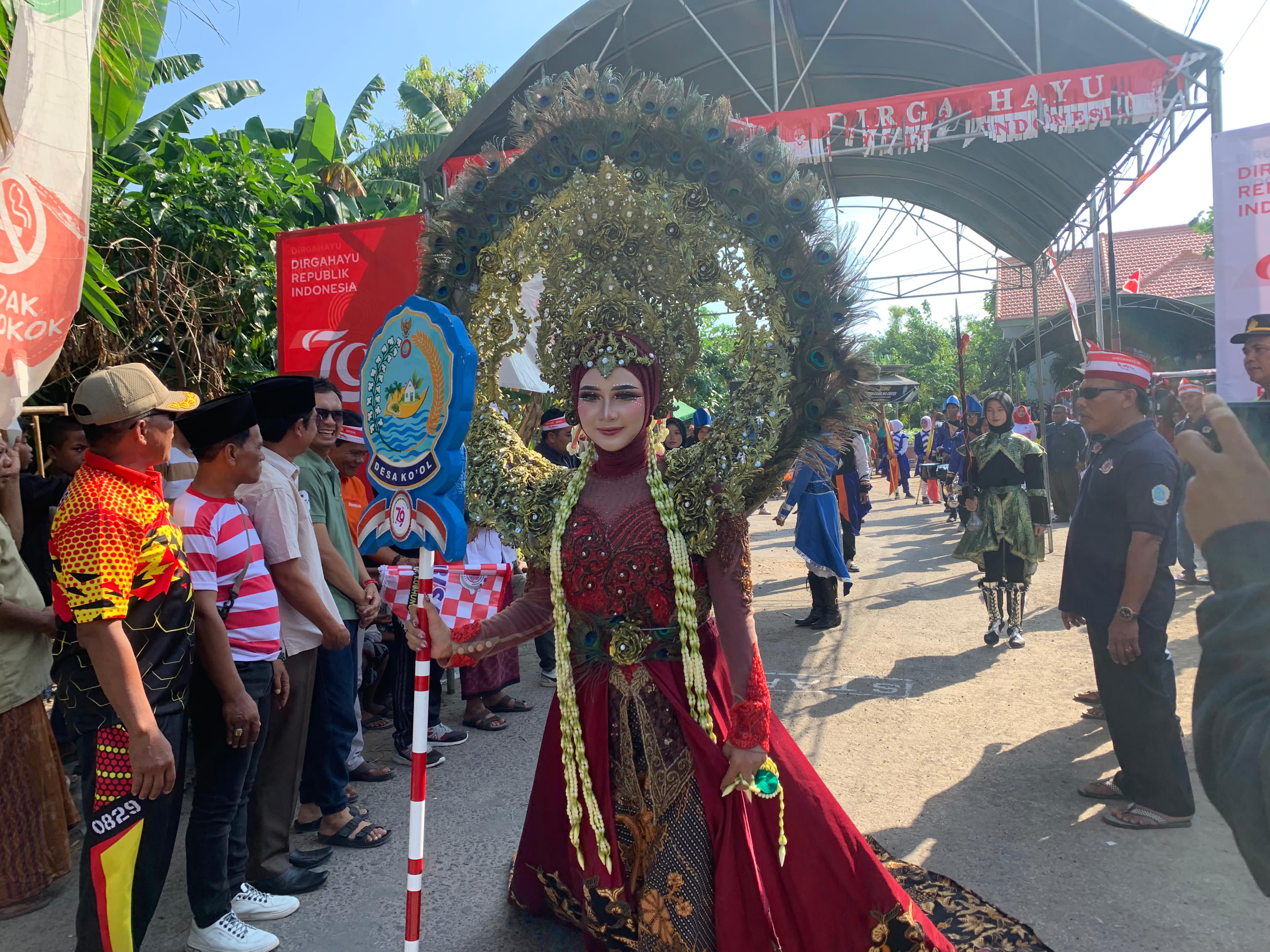 MEMUKAU: Peserta karnaval perayaan HUT ke-79 RI mengenakan kostum bertema Ratu Merak dan memegang tongkat berlogo Desa Kool, Minggu (18/8). (ISMI MUFLIHAH/JPRM)