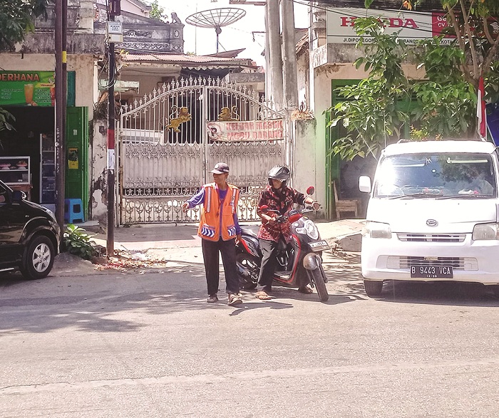 JUKIR: Petugas sedang mengatur kendaraan di Jalan Diponegoro, Kelurahan Bangselok, Kecamatan Kota Sumenep, Selasa (20/8). (MOH. LATIF/JPRM)