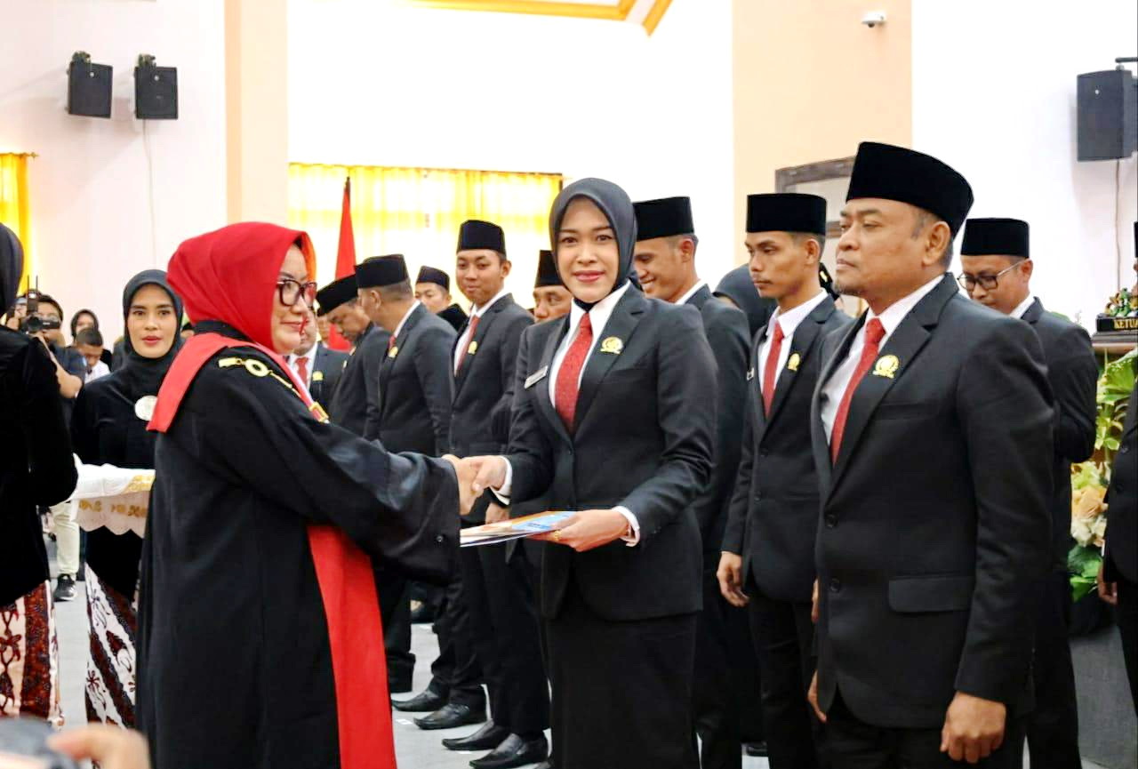RESMI: Vanny Dariyani menerima penyematan tanda jabatan anggota DPRD Sampang dari Ketua PN Sampang Ratna Mutia Rinanti di kantor dewan, Senin (26/8). (VANY DARIYANI UNTUK JPRM)