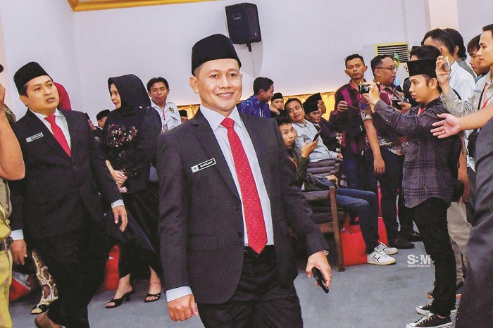 KARISMATIK: Anggota DPRD Sampang Fraksi PKB Baihaki keluar dari ruang paripurna usai pelantikan Senin (26/8). (BAIHAKI UNTUK JPRM)
