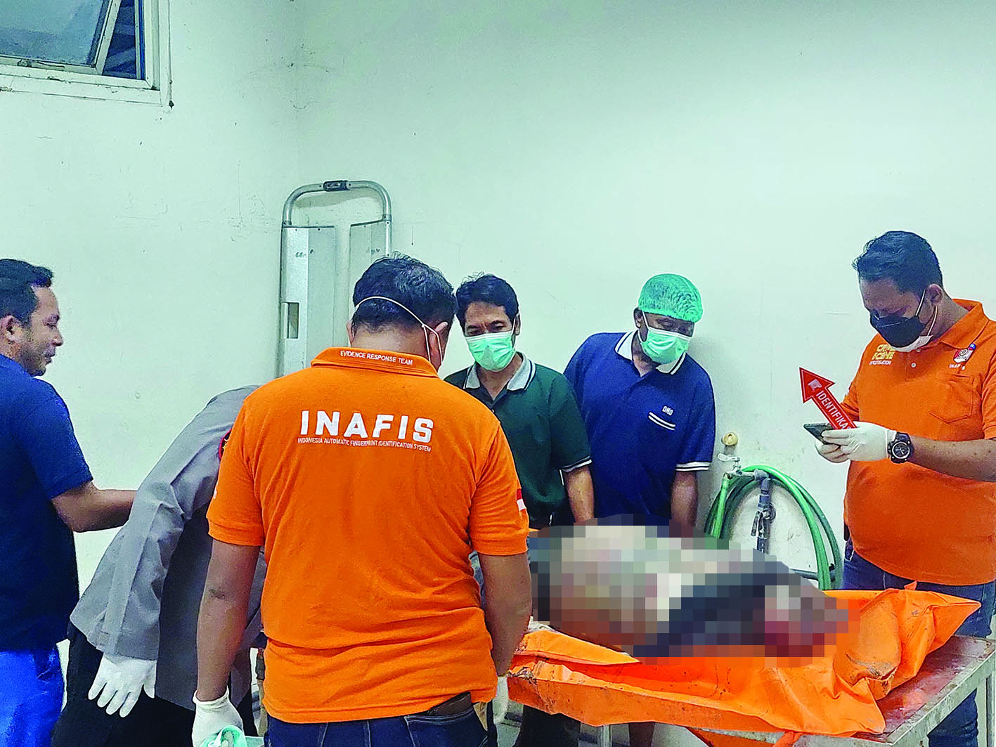TANPA IDENTITAS: Petugas memeriksa mayat tanpa identitas di Ruang Pemulasaraan Jenazah RSUD Syamrabu Bangkalan, Minggu (25/8). (ZEINAL ABIDIN/JPRM)