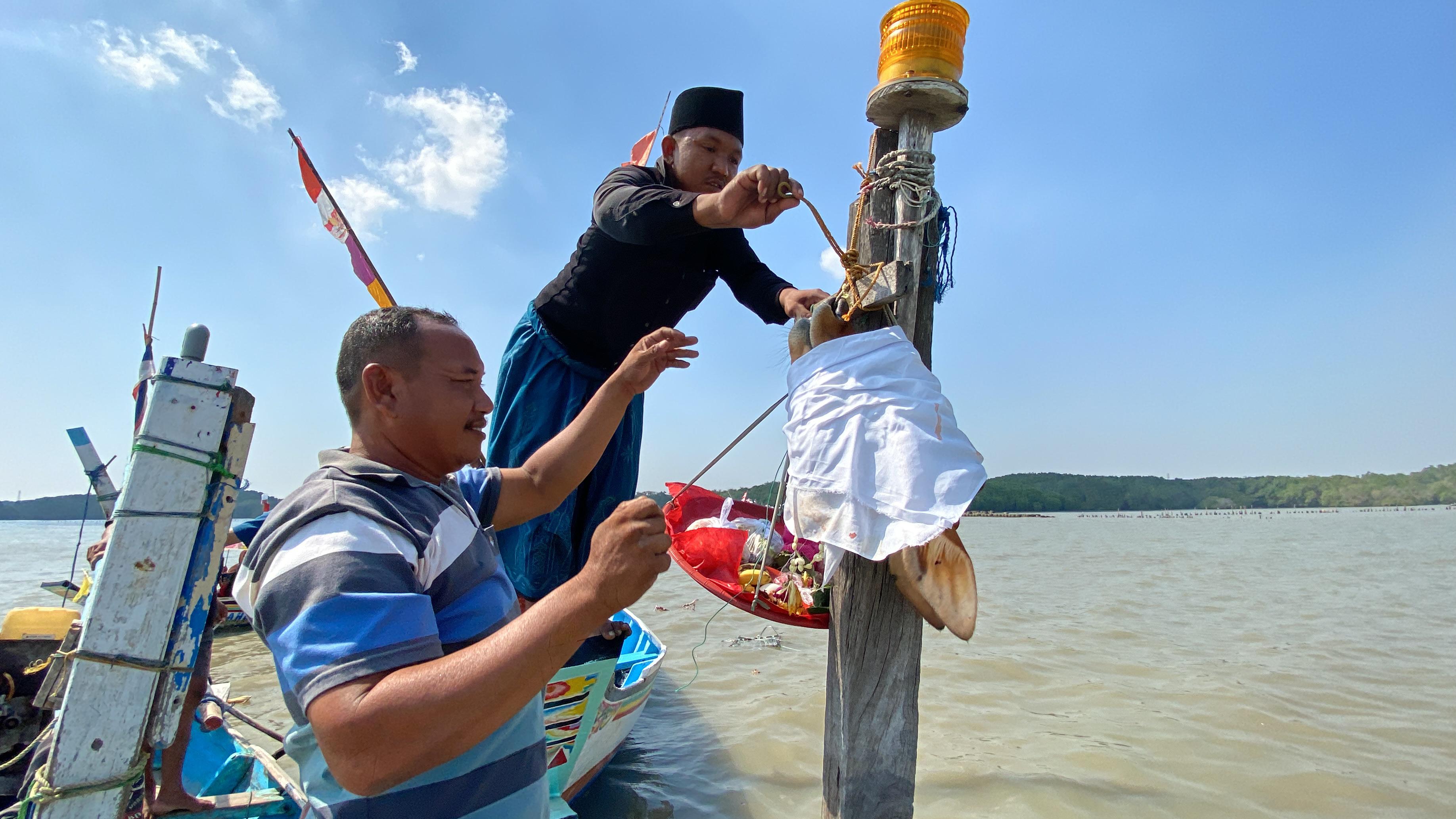 SAKRAL: Warga mengikat kepala sapi pada tiang kalabangan dalam ritual rokat tase&rsquo; di perairan Kampung Bandaran, Kelurahan Pejagan, Kecamatan Bangkalan, Minggu (25/8). (AYU LATIFAH/JPRM)