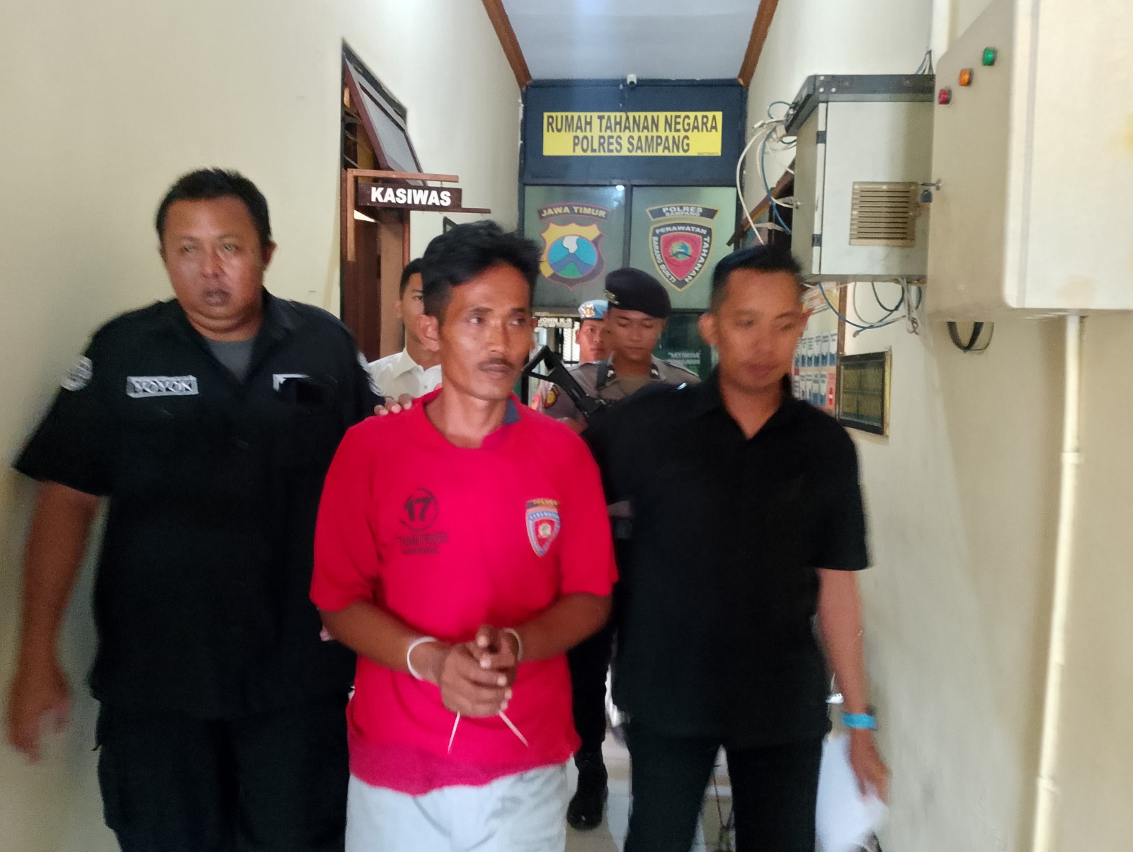 MELANGGAR HUKUM: Tersangka Omar digiring petugas di Mapolres Sampang saat konferensi pers, Rabu (28/8). (UBAIDILLAHIR RA&rsquo;IE/JPRM)