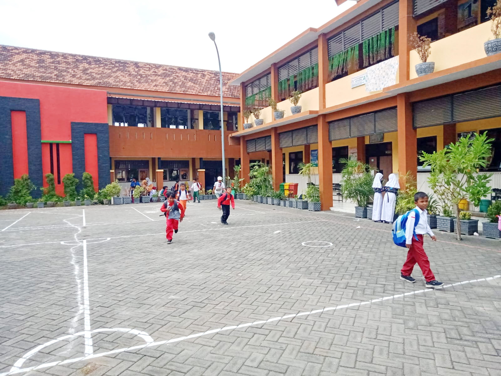 DALAM NAUNGAN DISPENDIK: Sejumlah siswa SD berada di halaman SDN Kemayoran 1, Jalan Raya Teuku Umar, Kemayoran, Bangkalan, Rabu (28/8). (IMAMUDIN/JPRM)