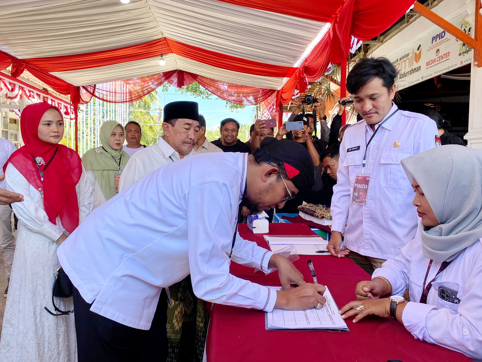 MENDAFTAR: Pasangan Achmad Fauzi Wongsojudo-Imam Hasyim mengisi daftar hadir ketika mendaftar ke KPU Sumenep kemarin. (MOH. JUNAIDI)