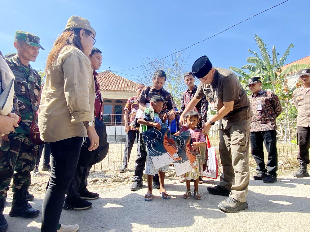 BOCAH VIRAL DAPAT BANTUAN: Pj Bupati Bangkalan Arief M. Edie memakaikan tas kepada M dan YB di Desa Sukolilo Barat, Kecamatan Labang, Bangkalan, Kamis (29/8).