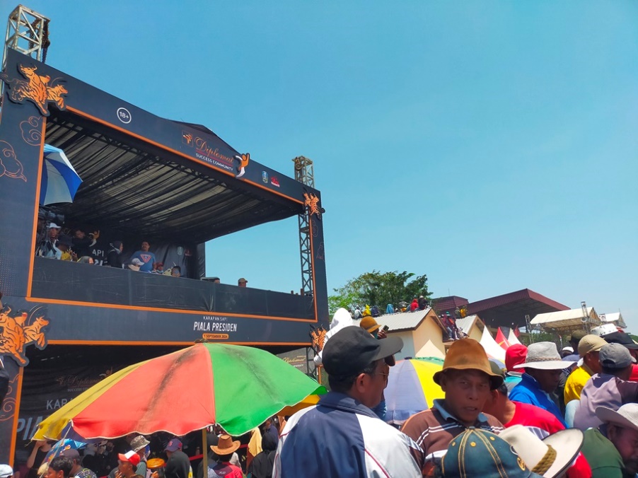 MEMBELUDAK: Para penonton Karapan Sapi Piala Presiden 2024 berada di depan panggung Wismilak Diplomat di Bangkalan.