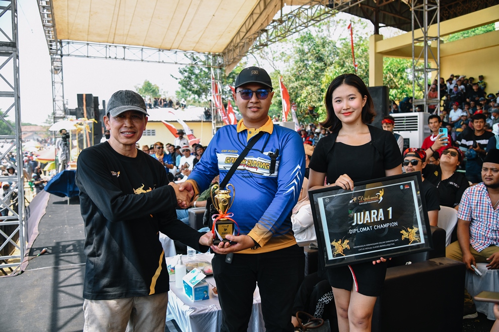 SUPPORT: Regional Manager Jawa Timur PT Wismilak Inti Makmur Tbk, Mawardi menyerahkan piala dan plakat penghargaan juara I Diplomat Champion di R.P Moch Noer, Bangkalan, Jawa Timur, Minggu (1/9).