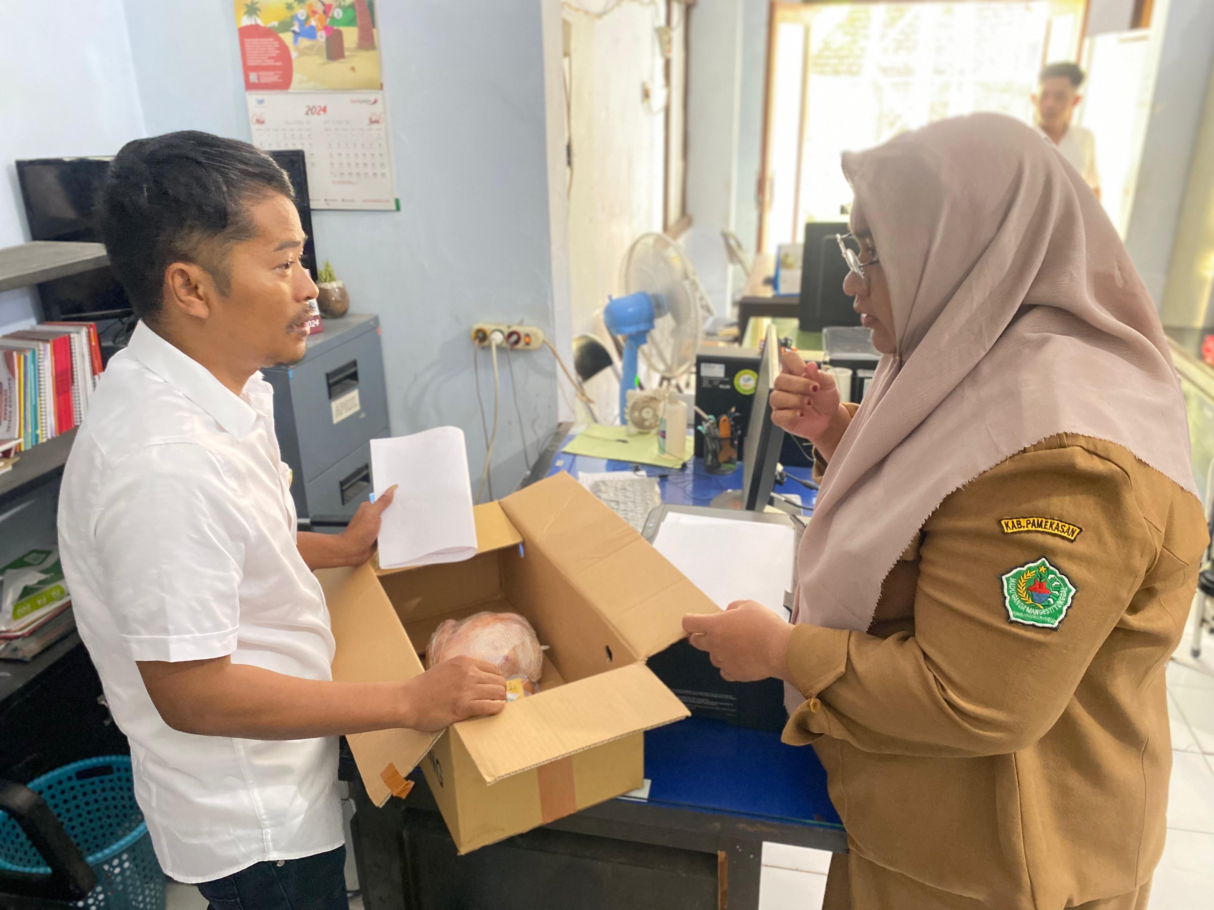 MENOLAK: Anggota DPRD Pamekasan Tabri Syaifullah Munir mengembalikan bantuan telur dan daging ke Dinsos Pamekasan, Senin (2/8). (MOH. IQBAL AFGANI/JPRM)