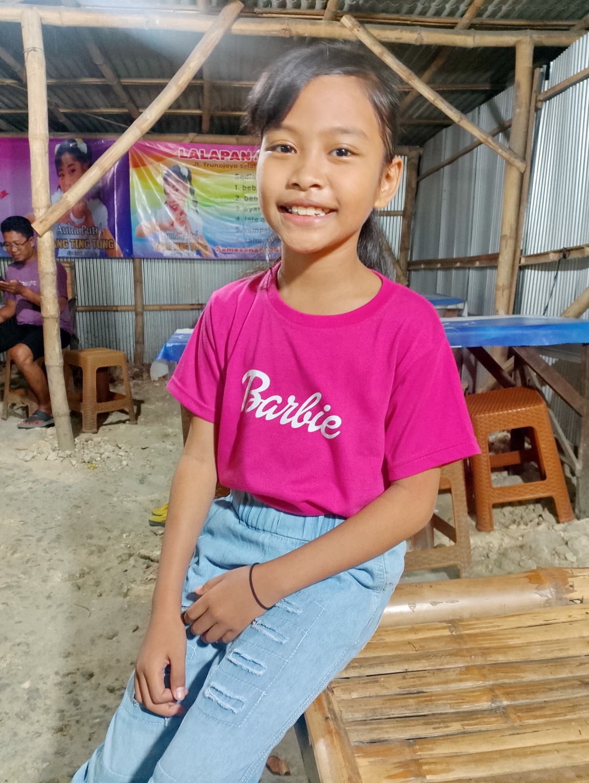 MURAH SENYUM: Aulia Putri sedang santai di Warung Lalapan Aulia Putri milik orang tuanya di Jalan Dipenogoro, Sampang, Kamis (29/8). (UBAIDILLAHIR RA&rsquo;IE/JPRM)
