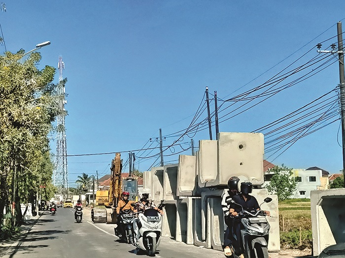 BAHAYAKAN PENGENDARA: Pengguna jalan melintasi Jalan dr Cipto di sela-sela tumpukan u-ditch pada Sabtu (7/9). (MOH. IQBAL/JPRM)