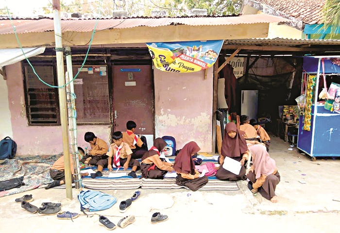 BELUM TERURAI: Murid SDN Tamberu 2, Kecamatan Batumarmar, Pamekasan, mengikuti KBM di emperan rumah warga, Sabtu (7/9). (ACH. RASYIDI UNTUK JPRM)