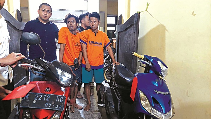 MENAHAN SAKIT: Abd. Muis dan Saiful Alim (kanan), dua tersangka curanmor digiring petugas ke ruangan penyidik Satreskrim Polres Bangkalan Selasa (10/9). (ZEINAL ABIDIN/JPRM)