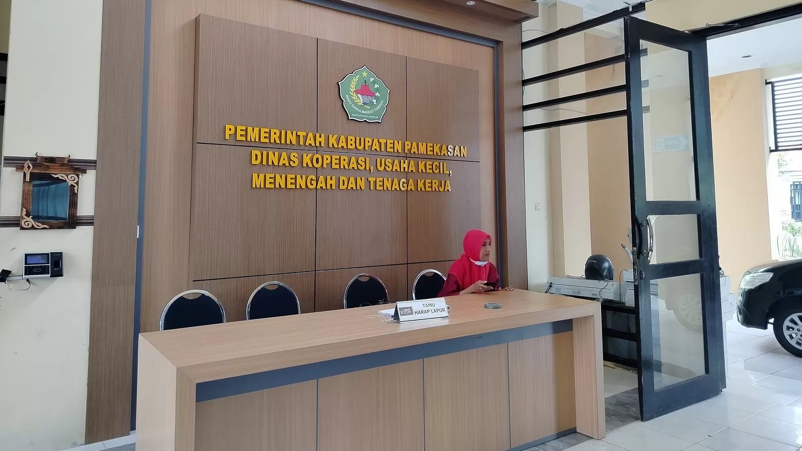 MELAYANI: Pegawai Diskop UKM dan Tenaga Kerja Pamekasan berada di meja resepsionis, Selasa (5/3). (LAILIYATUN NURIYAH/JPRM)