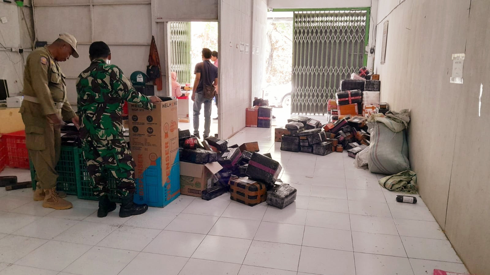 ILEGAL: Tim Operasi Gabungan Sampang melakukan pengamanan rokok ilegal di kantor J&T Express Drop Point Omben, Rabu (4/9). (SATPOL PP UNTUK JPRM)