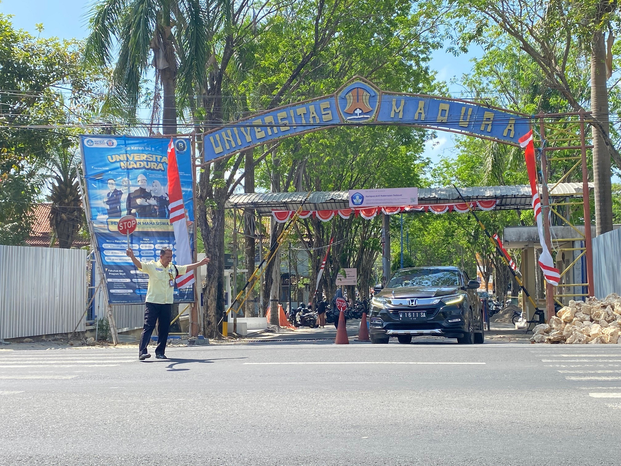 LINGKUNGAN PENDIDIKAN: Satpam mengawal mobil yang hendak keluar dari kampus Unira kemarin. (AYU LATIFAH/JPRM)