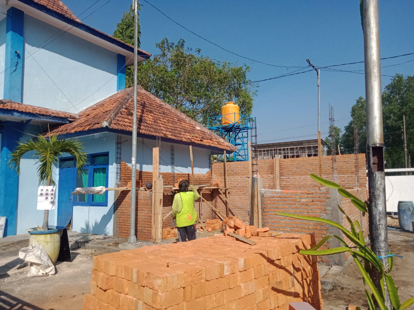 TERIK: Pekerja berada di area pembangunan ruang admin Trans Jatim rute V di Terminal B Bangkalan, Jalan Soekarno-Hatta, Kamis (12/9). (IMAMUDIN/JPRM)