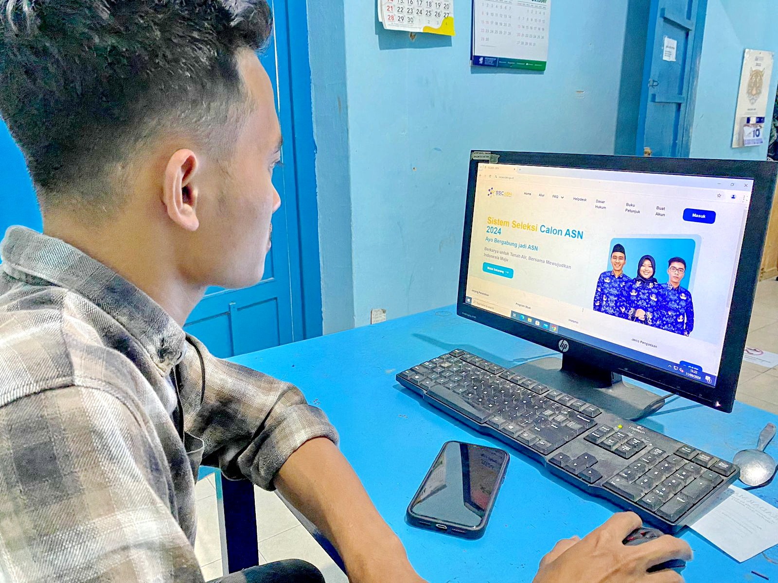 MENCOBA: Seorang peserta sedang membuka halaman CPNS di Jalan Kabupaten, Pamekasan, Rabu (11/9). (AYU LATIFAH/JPRM)