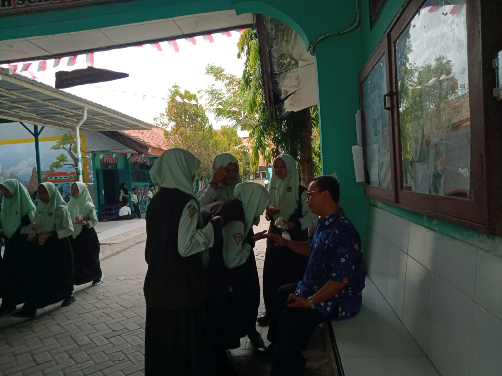 PAHLAWAN TANPA TANDA JASA: Siswa MTsN Bangkalan berpamitan pulang kepada guru, Rabu (28/8). (IMAMUDIN/JPRM)