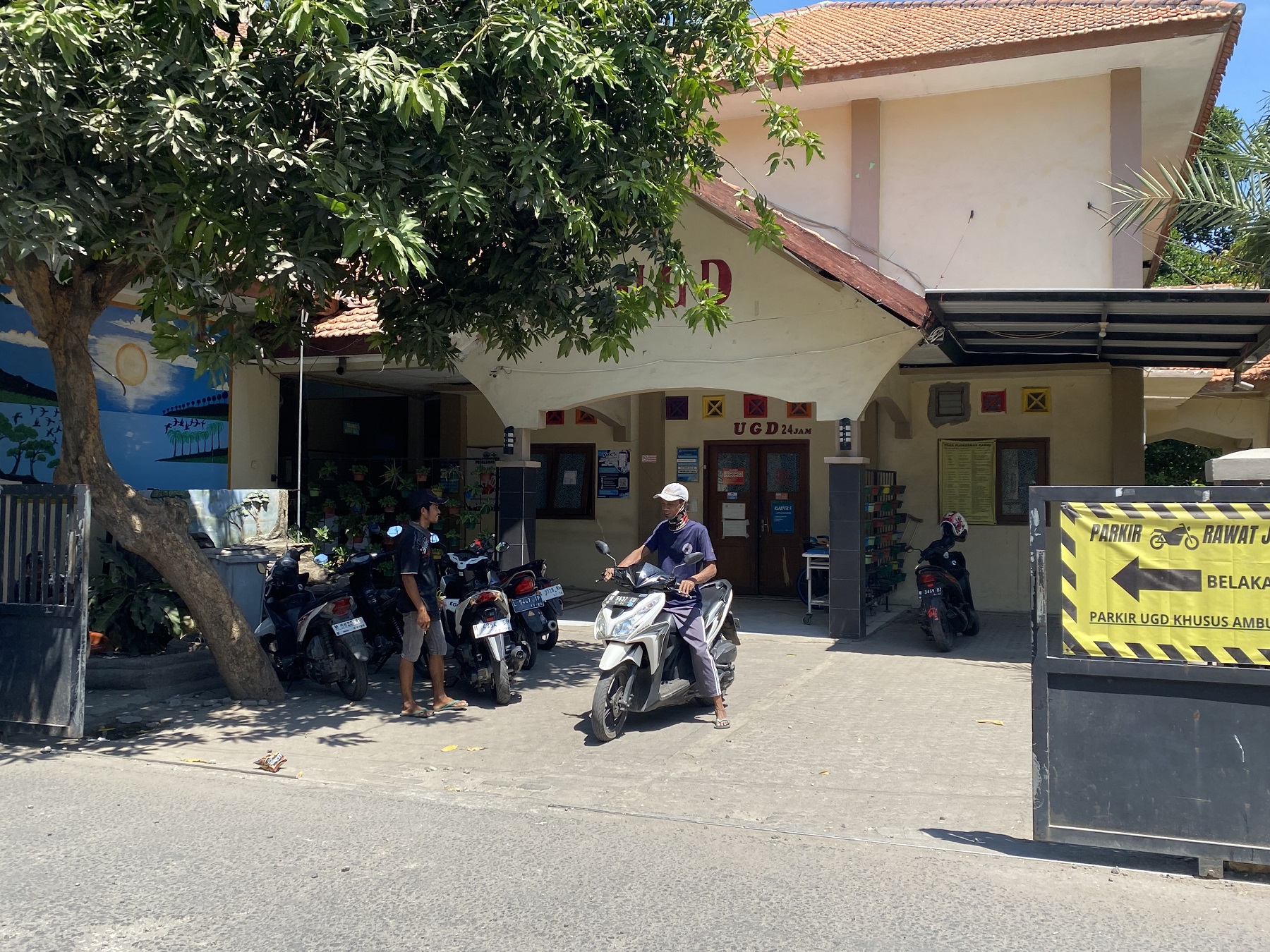 SULIT SURA RUJUKAN: Warga hendak keluar dari halaman Puskesmas Kamal Selasa (17/9).