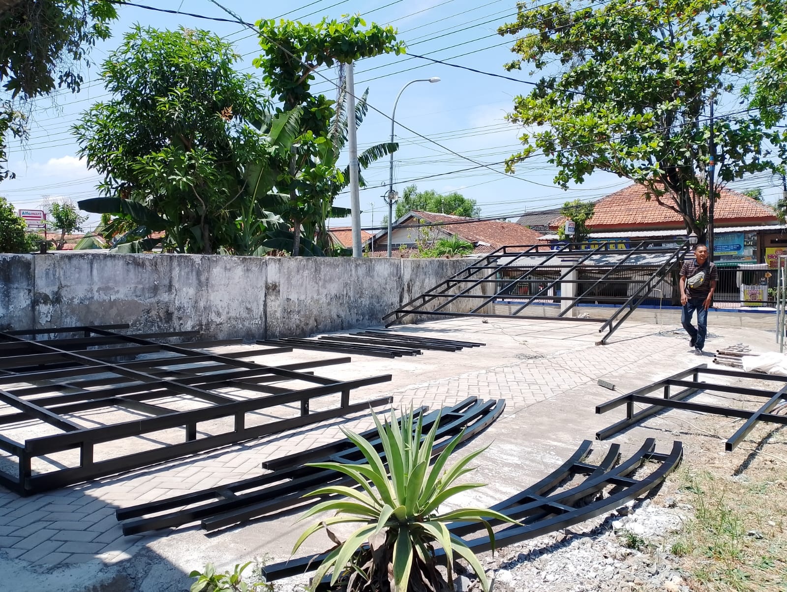 BELUM RAMPUNG: Pekerja mengerjakan pembangunan tempat parkir kantor Dispendukcapil Sampang, Selasa (17/9). (UBAIDILLAHIR RA&rsquo;IE/JPRM)