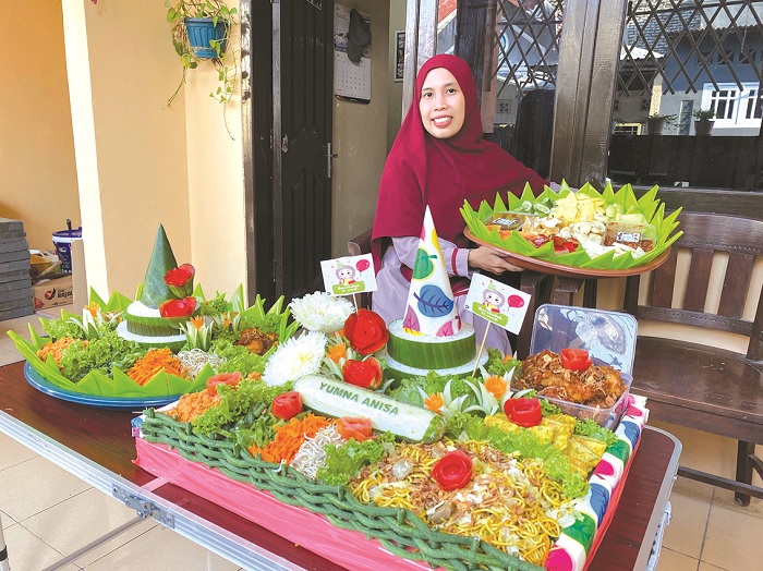 NGILER: Akutriyati menunjukkan rujak nampan dan tumpeng nasi olahannya di&nbsp;Perumahan Candra Land, Blok A, Nomor 7, Kelurahan Mlajah, Bangkalan, Jumat (6/9). (AYU LATIFAH/JPRM)