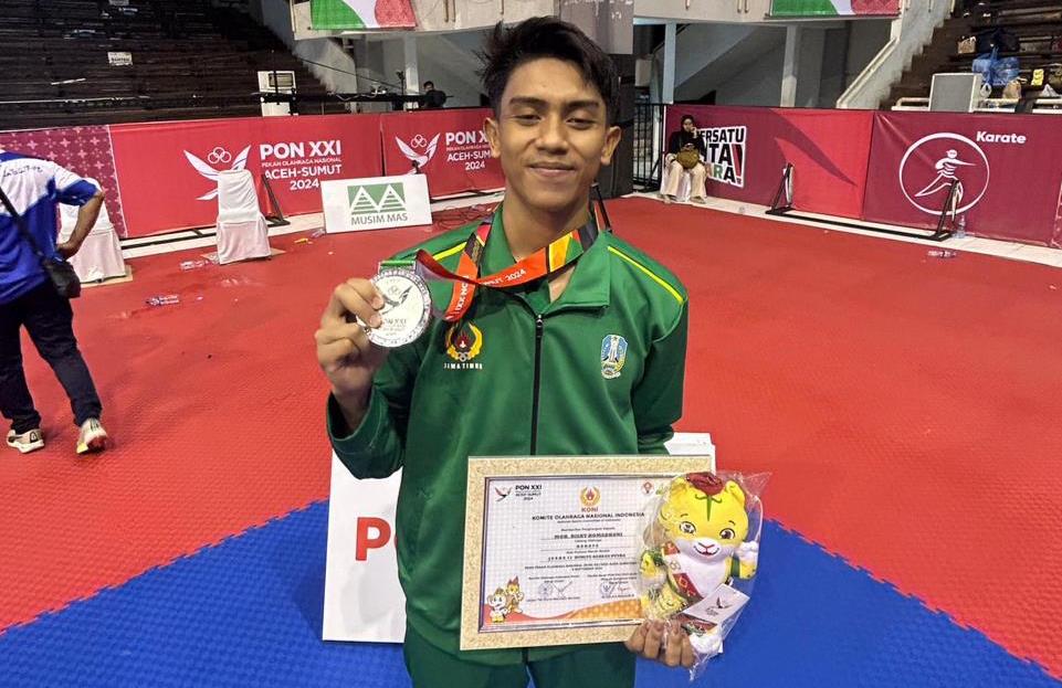 KUMITE BEREGU: Atlet karate Pamekasan Moh. Risky Romadhoni menunjukkan medali perak yang didapatkan dari PON XXI Aceh-Sumut, Rabu (18/9) malam.