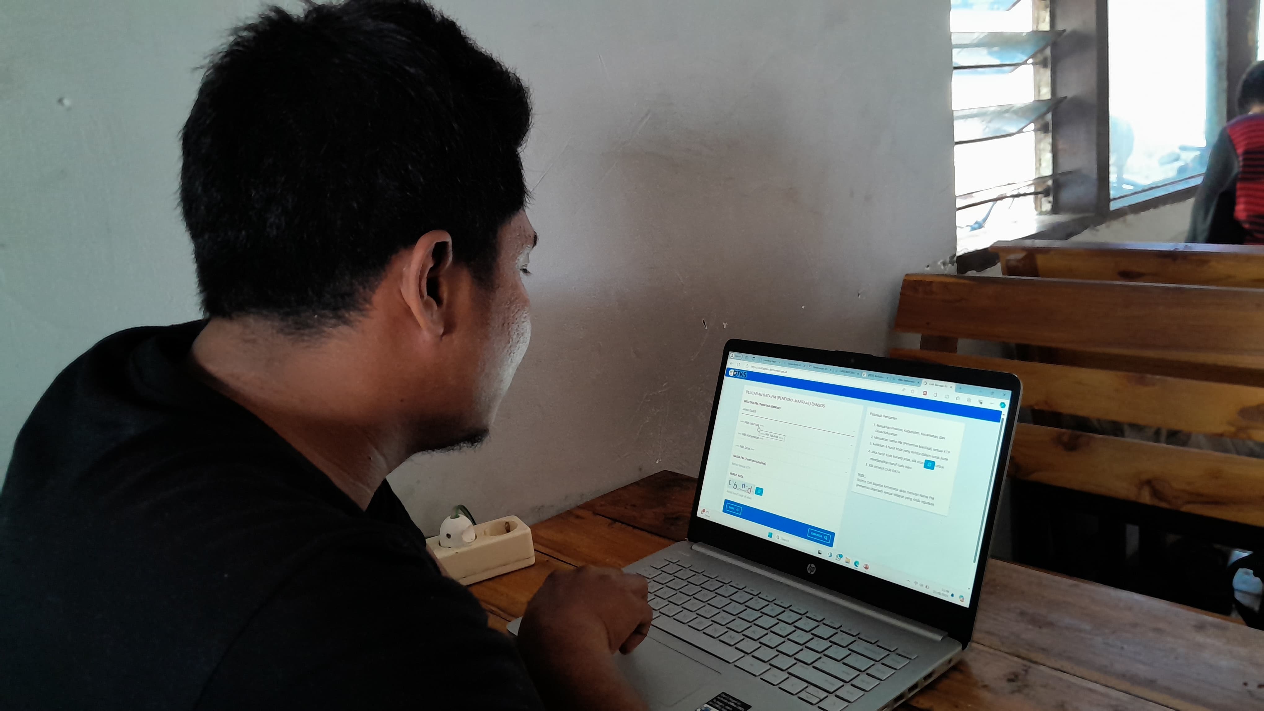 DEPAN LAYAR: Warga Larangan Tokol, Kecamatan Tlanakan, mengecek data dirinya di DTKS kemarin. (M. KHOLIL RAMLI/JPRM)