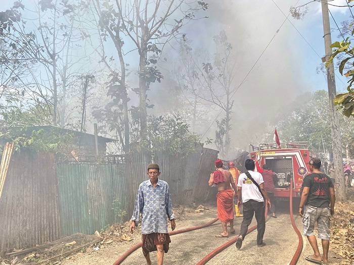 MENGEPUL: Sejumlah warga dan petugas damkar berusaha memadamkan api di gudang rongsokan Desa Blumbungan, Kecamatan Larangan, Pamekasan, Senin (23/9). (AYU LATIFAH/JPRM)