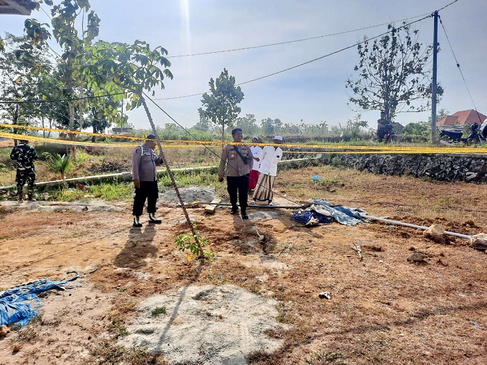 KAWASAN BAHAYA: Anggota Polsek Kedungdung sedang berada di TKP sumur bor yang diduga bercampur solar di Desa Batoporo Timur, Kecamatan Kedungdung, Sampang, beberapa waktu lalu.