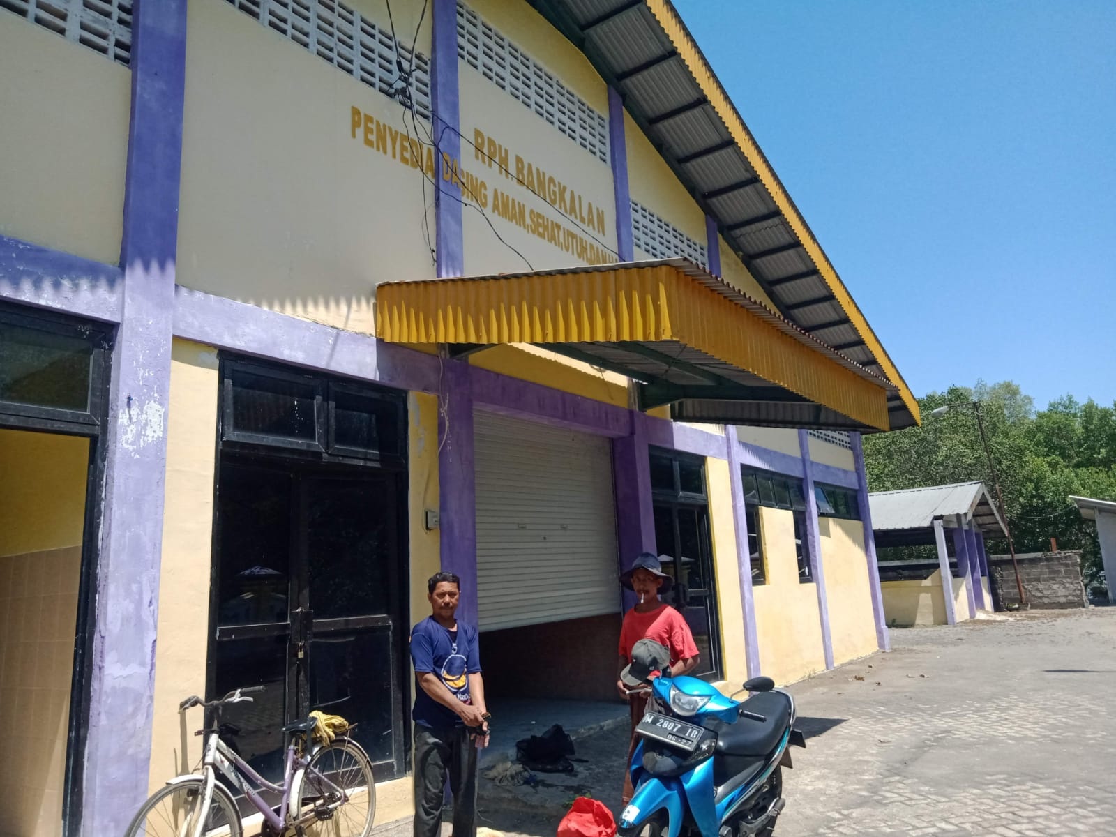 TERIK:&nbsp; Dua orang berada di depan RPH Bangkalan, Kelurahan Bancaran, Kecamatan Bangkalan, Jumat (30/8). (IMAMUDIN/JPRM)
