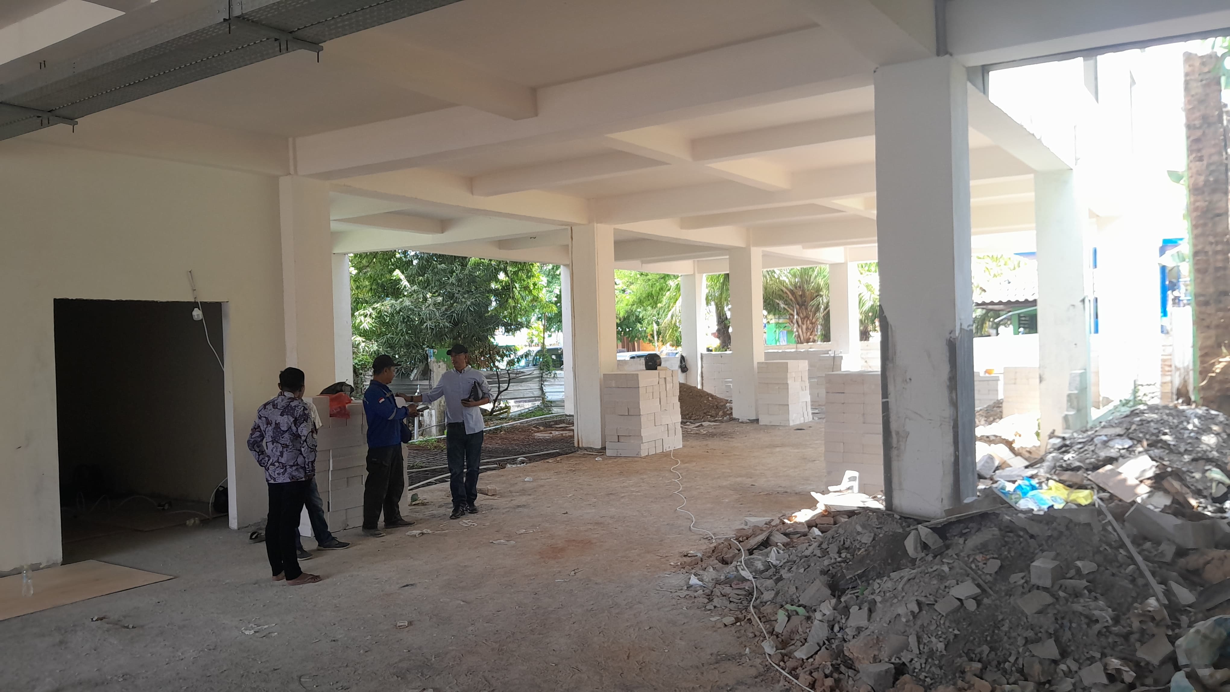 DIKERJAKAN: Kontraktor proyek pembangunan gedung Perpustakaan Daerah Pamekasan melakukan kontrol, Kamis (26/9). (KHOLIL RAMLI/JPRM)
