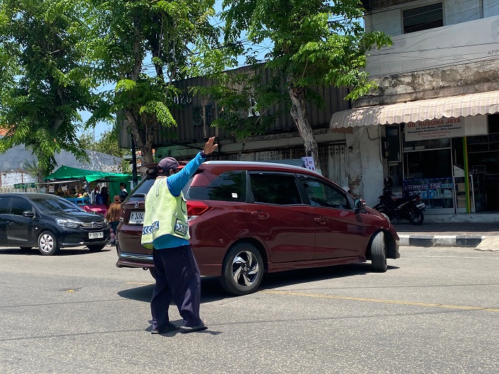 TERTIB: Seorang jukir mengarahkan kendaraan roda empat di Jalan Trunojoyo, Senin (30/9). (AYU LATIFAH/JPRM)