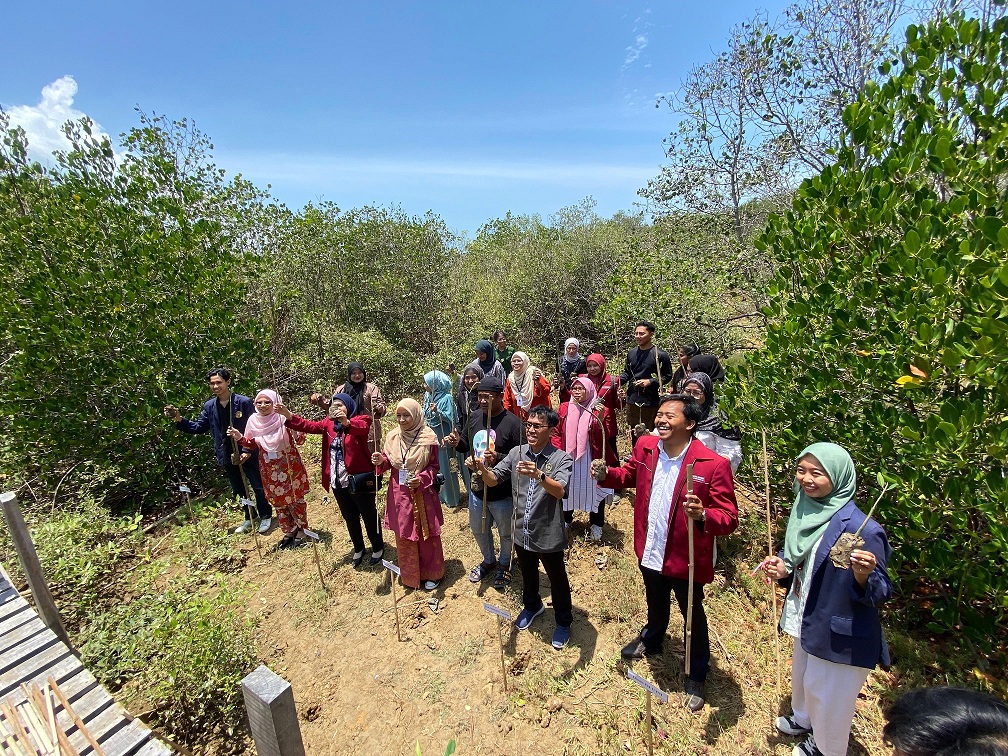SIMBOLIS: Mahasiswa FH UTM bersama mahasiswa FH dan HI Unisza Malaysia menunjukkan pohon bakau sebelum penanaman di Wisata Mangrove Kedatim, Desa Kebundadap Timur, Kecamatan Saronggi, Sumenep.