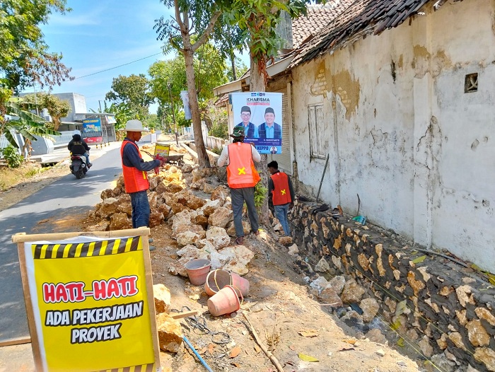 TAAT ATURAN: Pekerja terlihat mengenakan APD saat menggarap proyek pembangunan drainase di Desa Polagan, Kecamatan Galis, Pamekasan, Rabu (2/10). (AYU LATIFAH/JPRM)