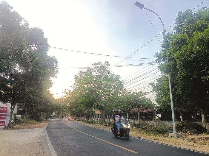 TEGAK BERDIRI: Pengendara motor melintas di bawah lampu PJU yang terpasang di Jalan Slamet Riyadi, Desa Pabian, Kecamatan Kota Sumenep, Kamis (3/10). (MOH. IQBAL/JPRM)
