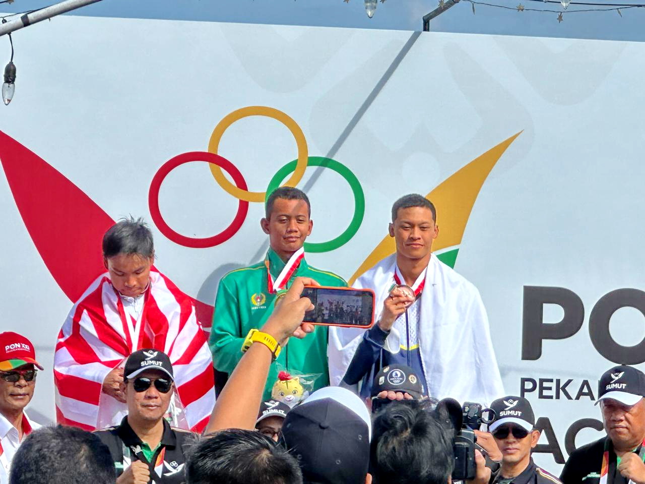 BERPRESTASI: Atlet renang Bangkalan Moh. Akbar Putra Taufik menerima medali emas pada PON XXI Aceh-Sumut, Rabu (11/9).