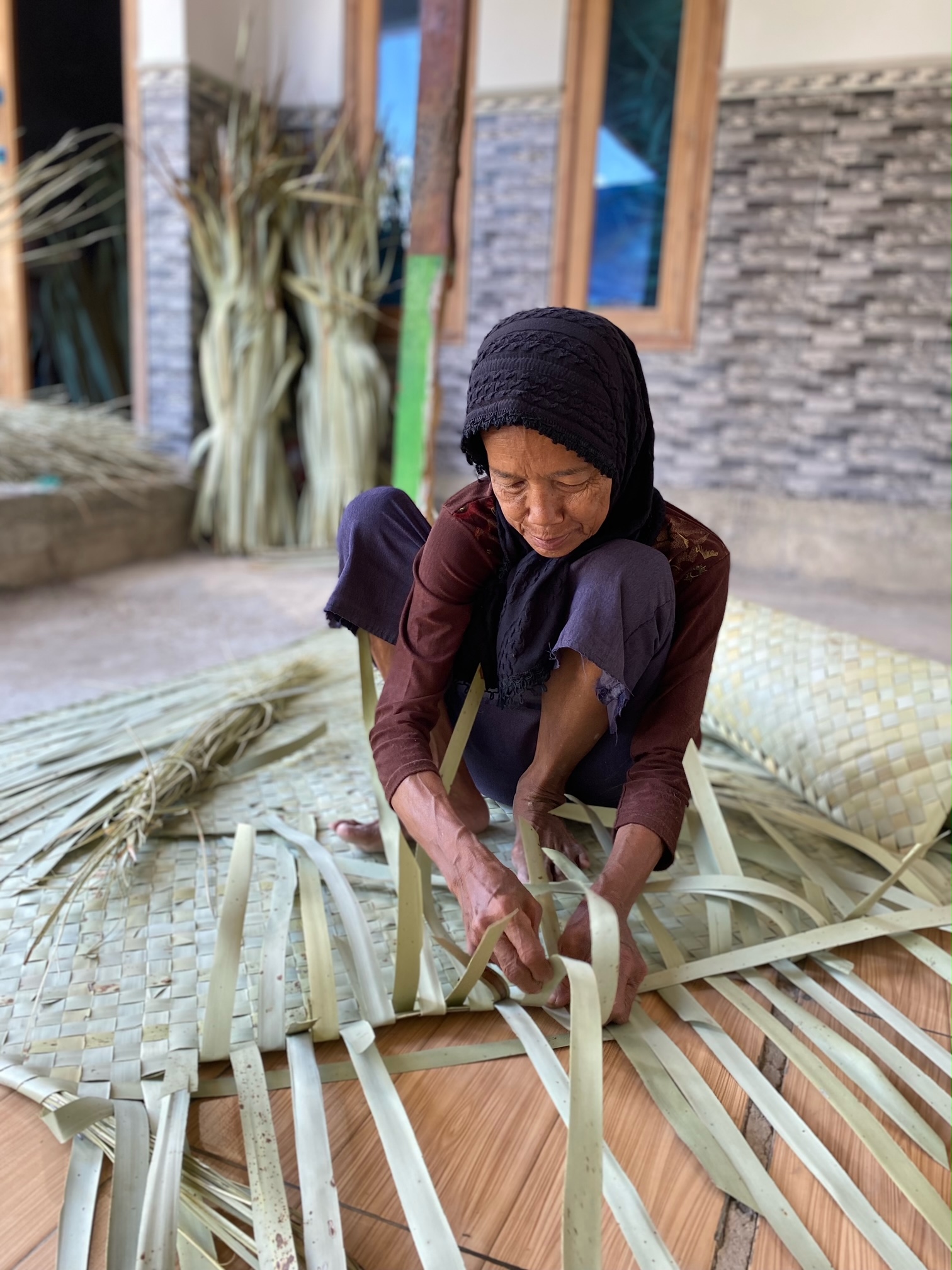ALAMI: Yunsanah menganyam tikar di Desa Kertagena Laok, Kecamatan Kadur, Pamekasan, Sabtu (22/9). (AYU LATIFAH/JPRM)