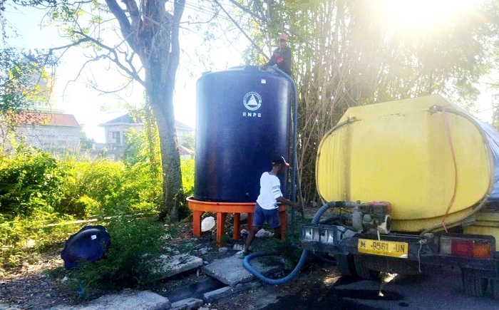 TERBATAS: Petugas mengisi tandon penampungan air bersih untuk pelanggan di Kelurahan Polagan, Kecamatan Sampang, Kamis (10/10). (BINZAR UNTUK JPRM)