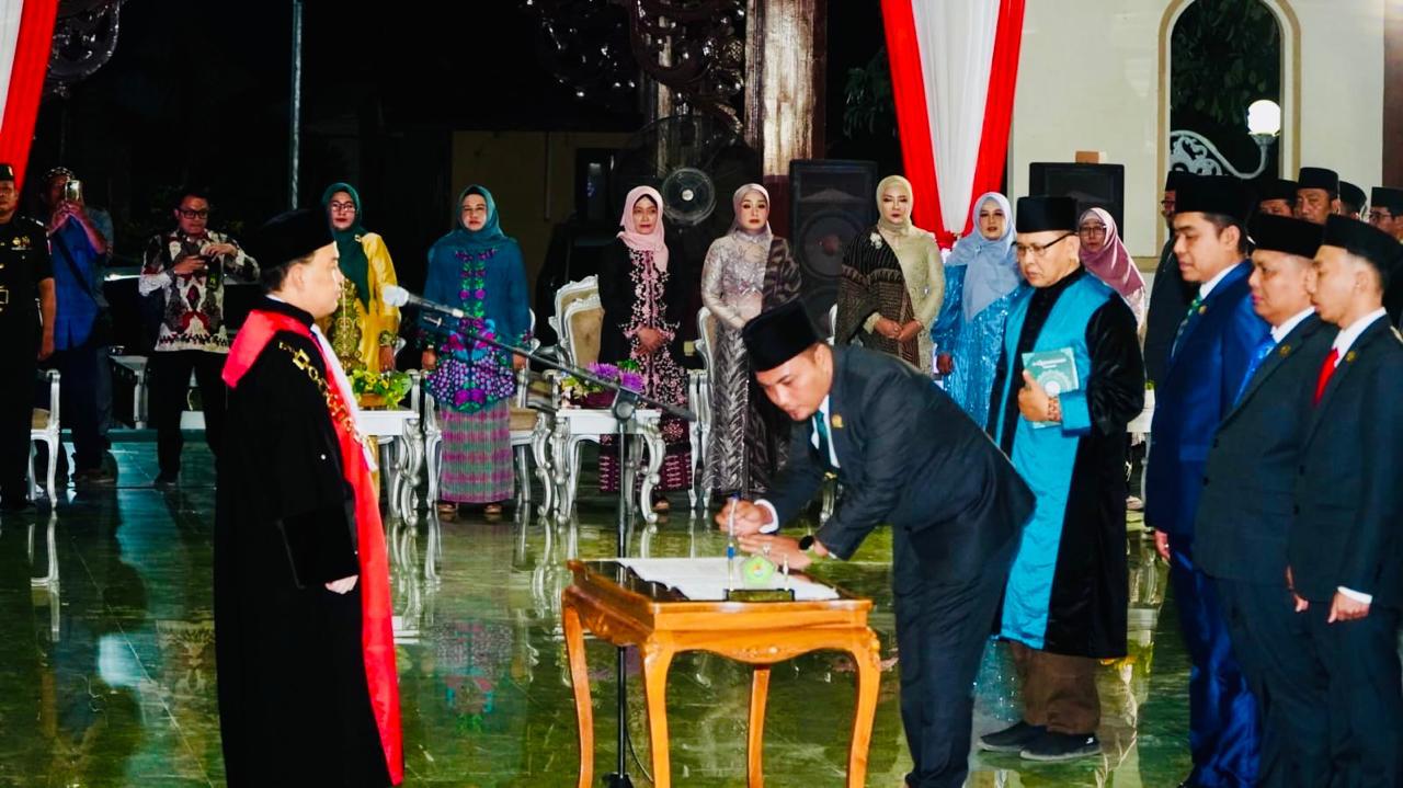 PUNYA KOMITMEN: Wakil Ketua DPRD Pamekasan Khairul Umam menandatangani berkas pelantikan di Mandhapa Agung Ronggosukowati, Kamis (10/10) malam. (SEKRETARIS DPRD PAMEKASAN UNTUK JPRM)