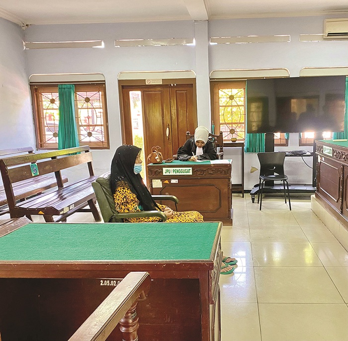 TERMENUNG: Terdakwa Helminah mendengarkan vonis pidana di PN Pamekasan Rabu (16/10). (MOH. IQBAL AFGANI/JPRM)