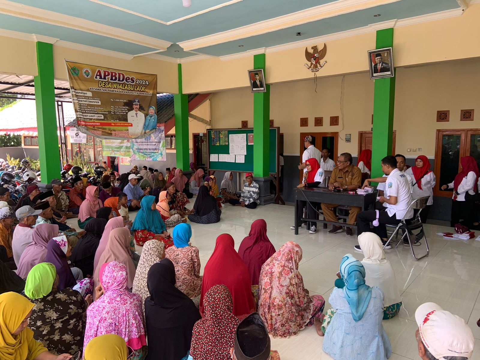 BANTUAN: Petugas Dinsos Pamekasan menyalurkan bantuan PKH plus di Desa Nyalabuh Laok, Kecamatan Pamekasan, Selasa (27/8). (DINSOS UNTUK JPRM)